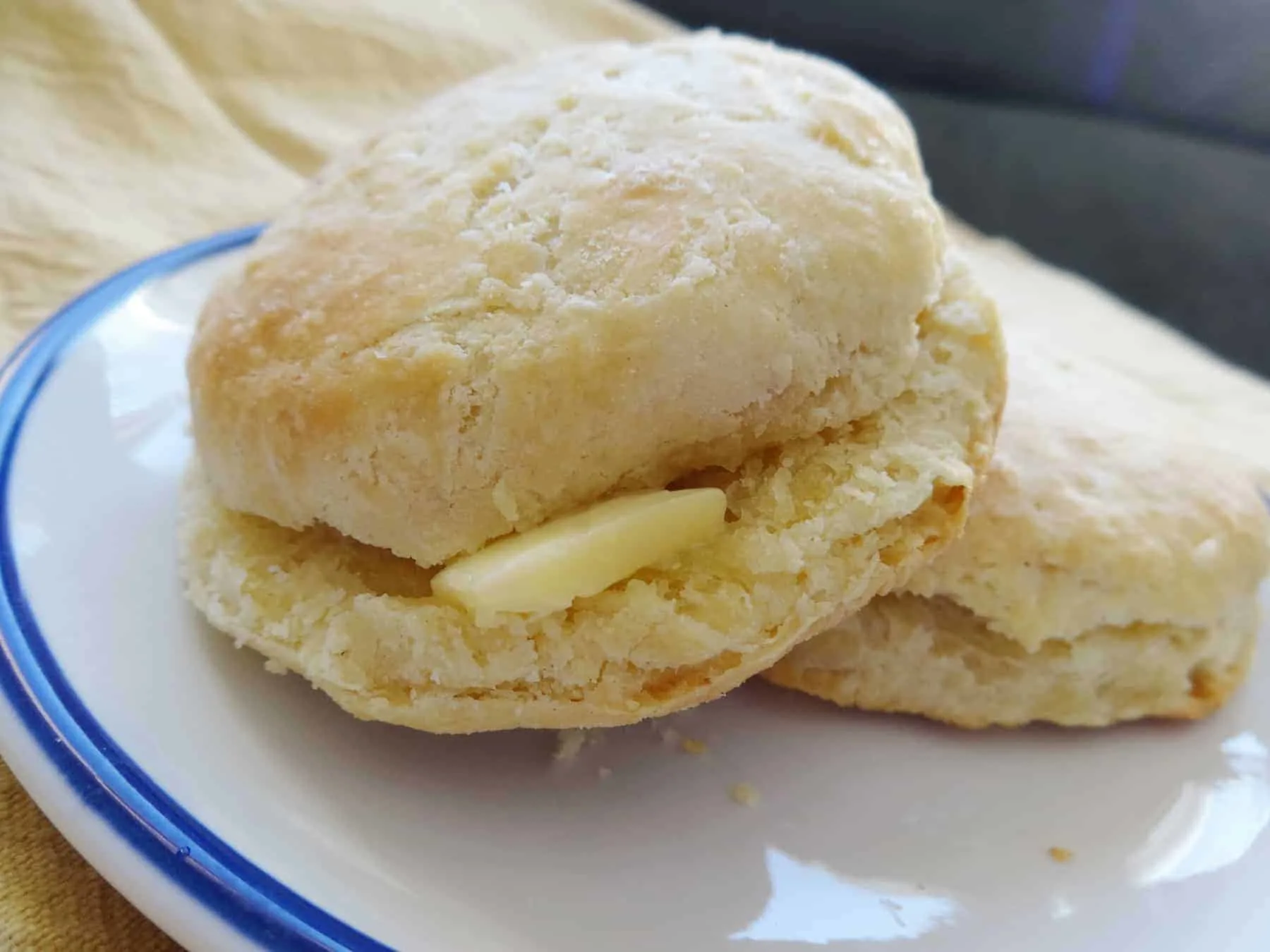 Two yeast-free biscuits on a blue and white plate.