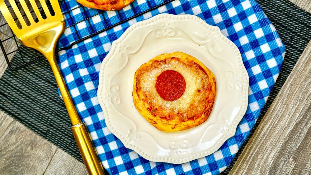 One pepperoni pizza on a plate with a spatula.