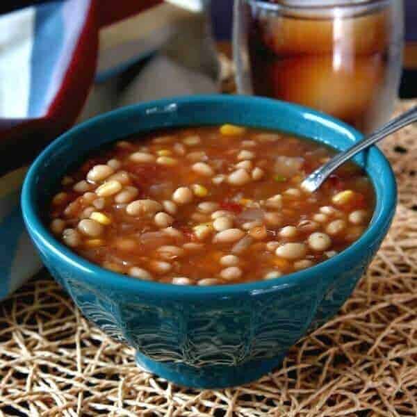 Slow cooker navy bean soup in a blue bowl.