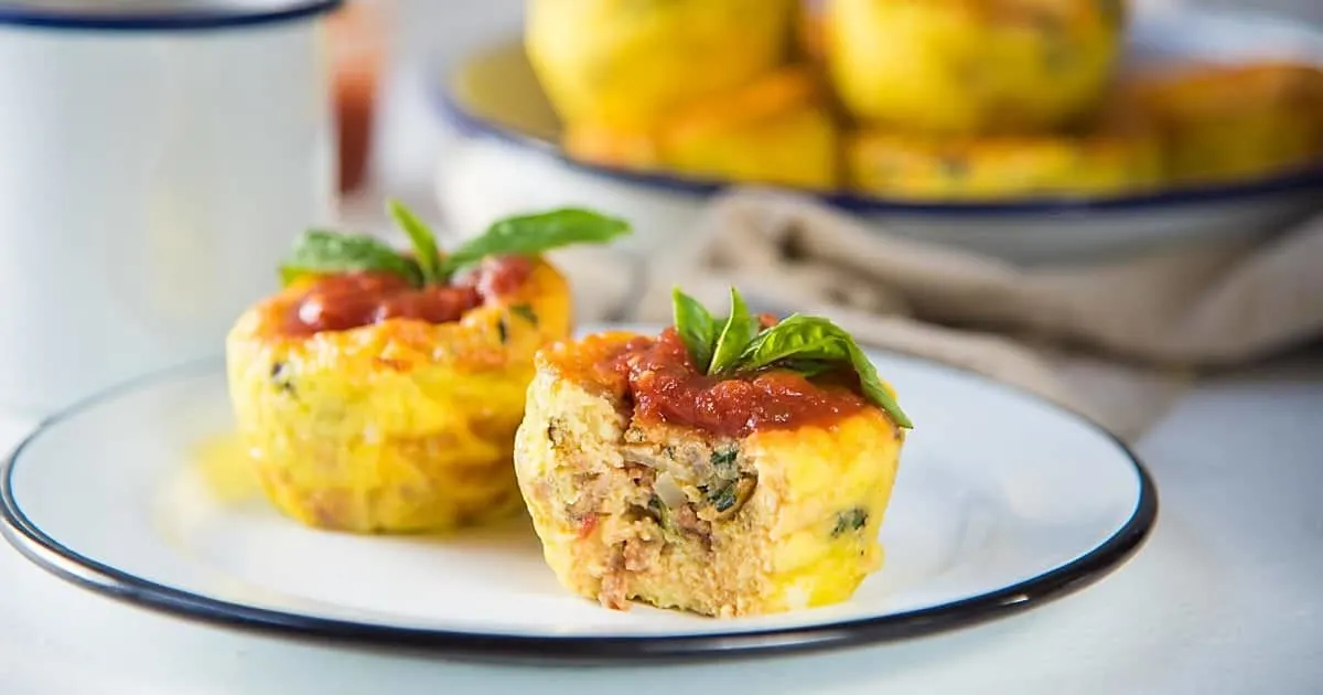 Two pizza egg muffins on white plate.