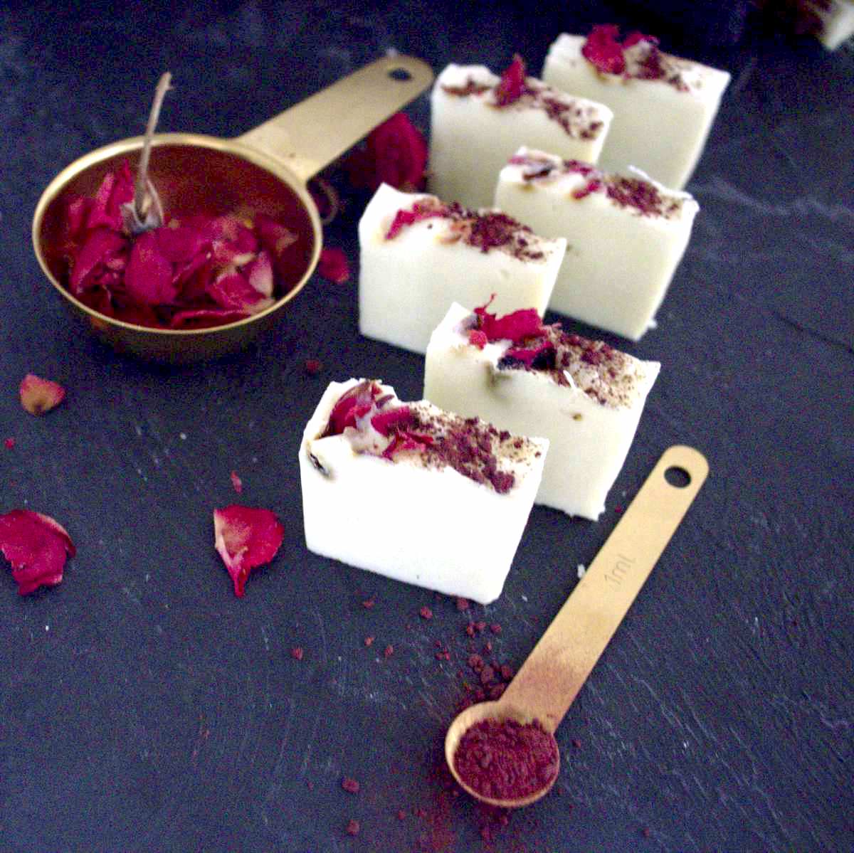 White rose soap bars with rose petals on the side.