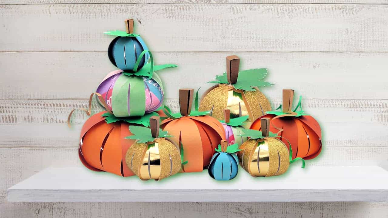 3D colorful paper pumpkin crafts with white wood background.