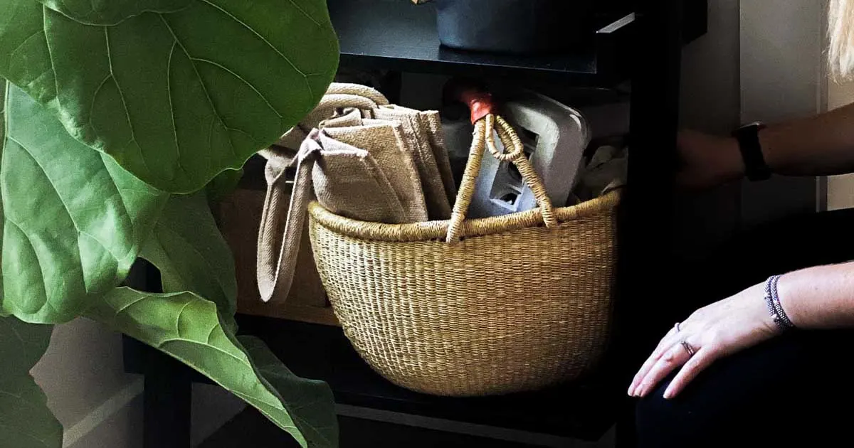 A wicker basket next to a plant.