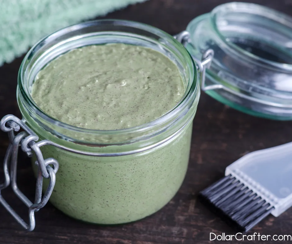Homemade aloe green tea face mask in an open jar next to an applicator brush.