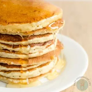 A stack of copycat McDonald's pancake with dripping pancake syrup in a white plate.