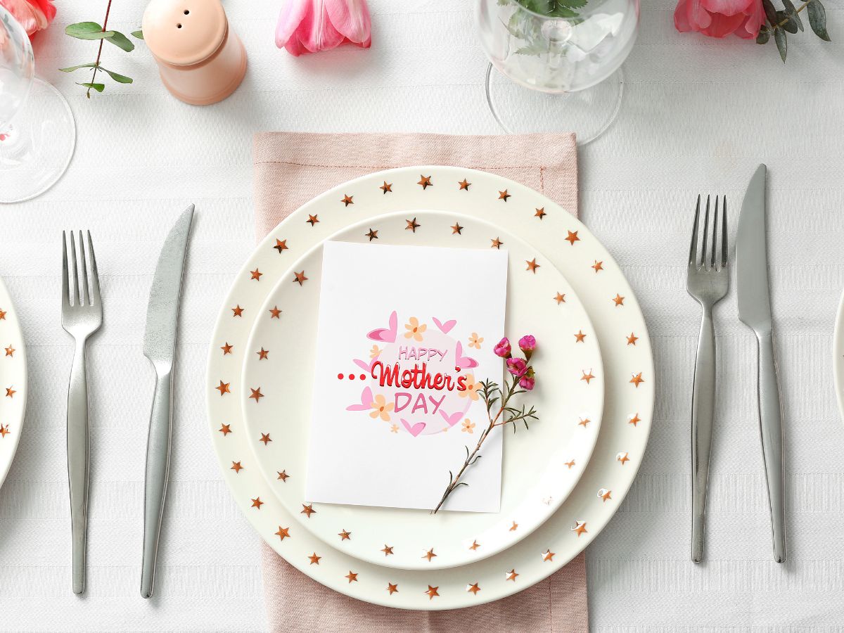 Place setting at a table with a Happy Mother's Day card on the plate.