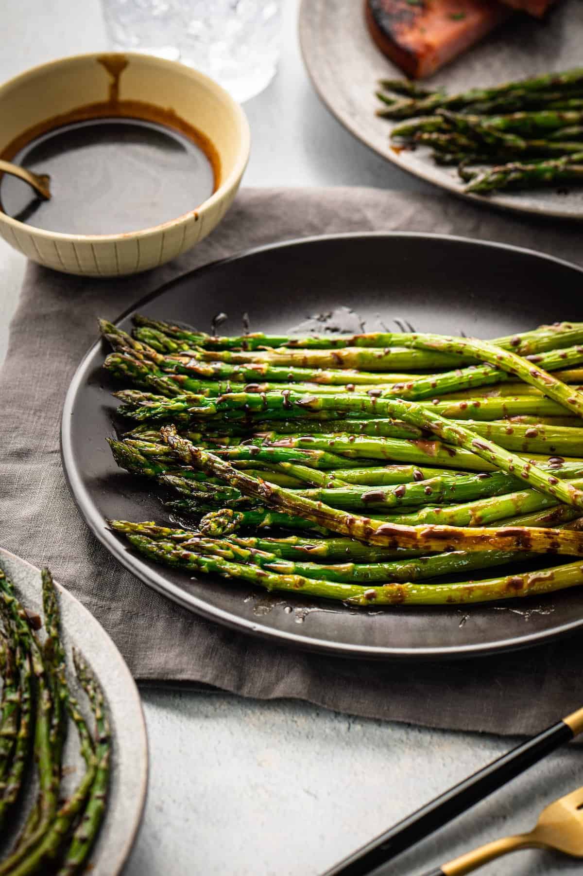 Grilled asparagus with sauce on a plate.