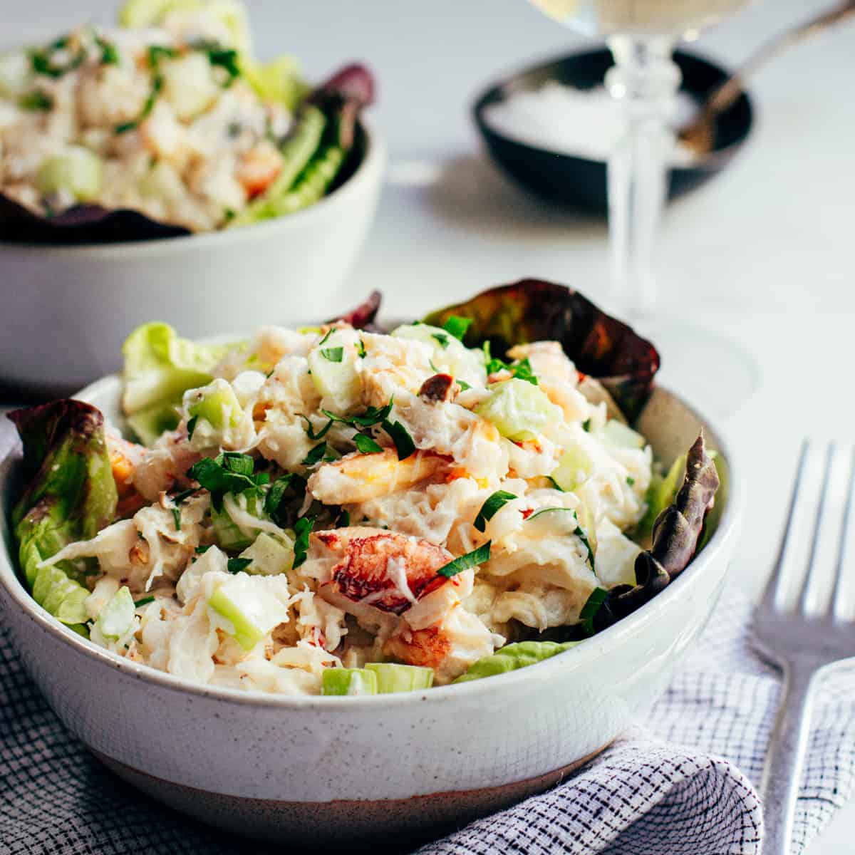 Two bowls of crab salad with a fork.