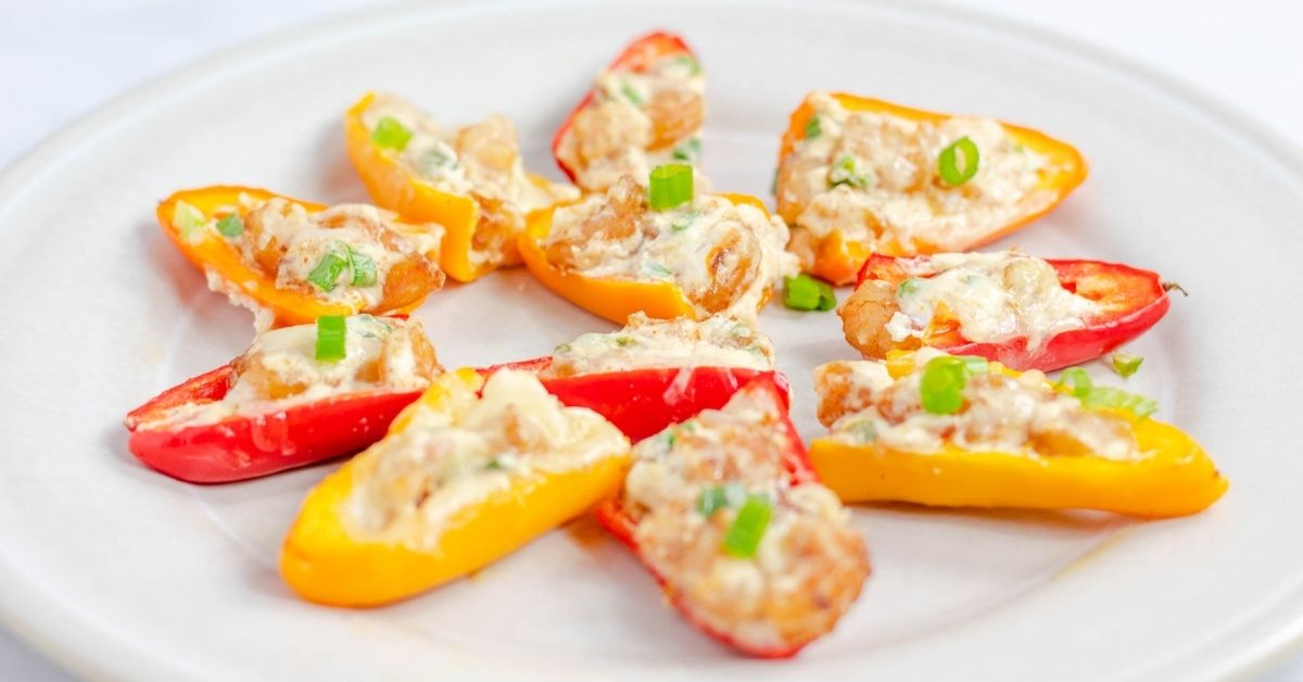 Stuffed bell peppers with shrimp rangoon and green onions on a plate.