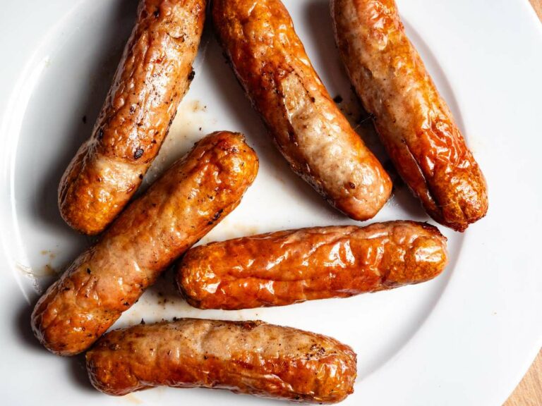 Breakfast sausages on a plate on a wooden table.