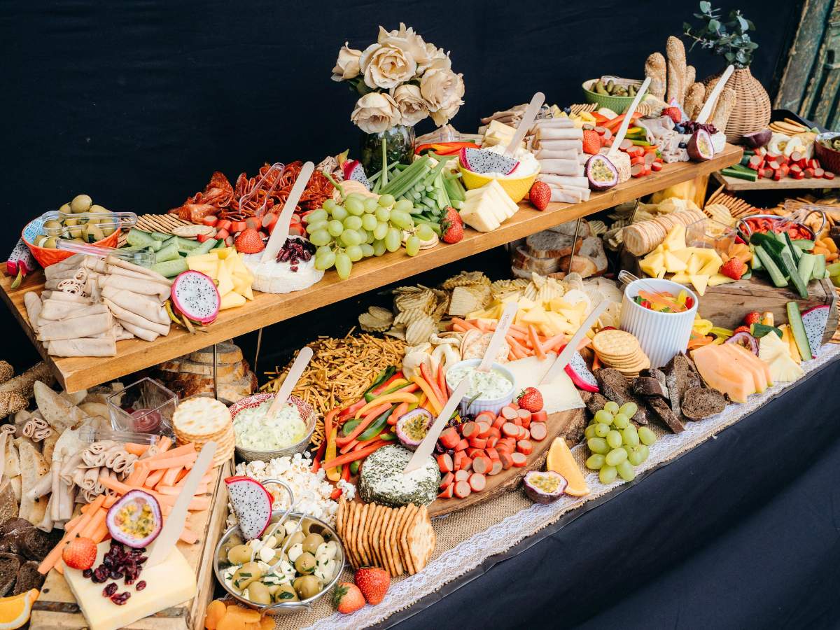 A two-tiered buffet table and a variety of serving utensils are present.