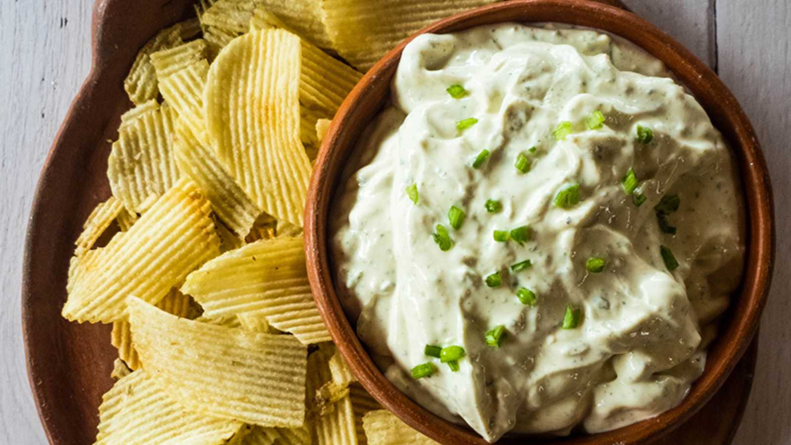 A picture of the best chip dip with potato chips on a tray.