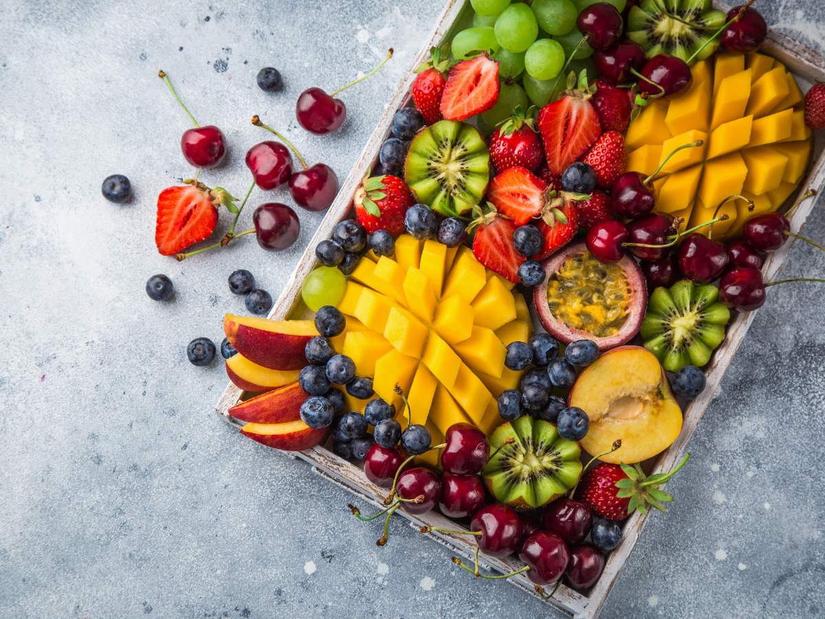 A wooden tray filled with an assortment of fresh fruits.