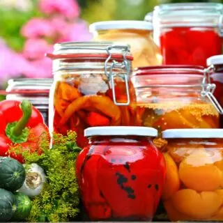 An assortment of pickled vegetables in glass jars.