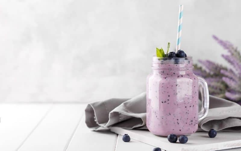 Blueberry smoothie, garnished with fresh blueberries.