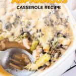 Chicken asparagus casserole in a baking dish with a serving spoon.