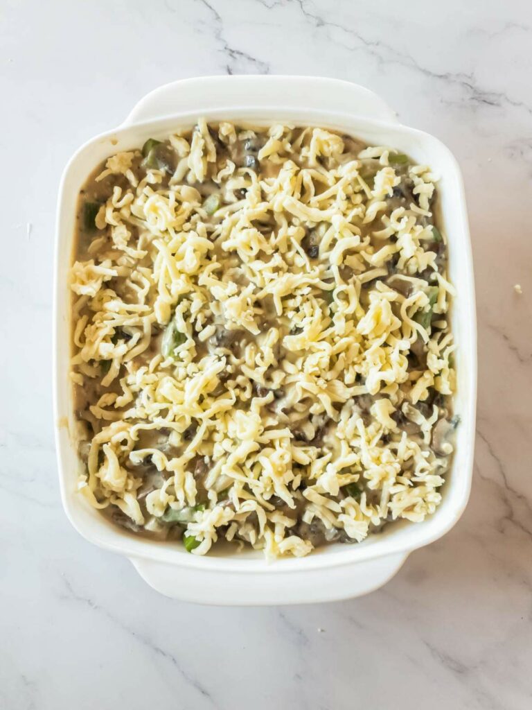 An overhead view of unbaked chicken asparagus casserole in a white dish.