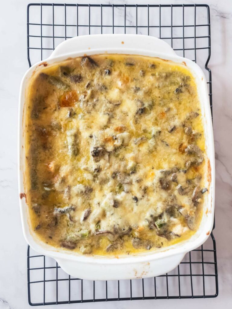 Chicken asparagus casserole in a white dish placed on a cooling rack.