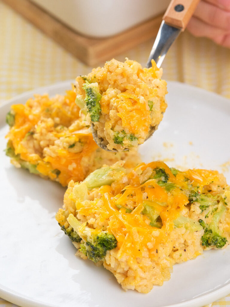 A plate with a serving of broccoli rice casserole, with a fork lifting a portion.