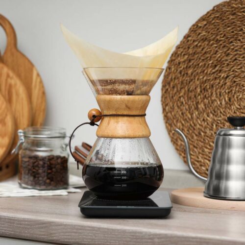 A pour-over coffee maker with freshly brewed coffee sits on a kitchen countertop.