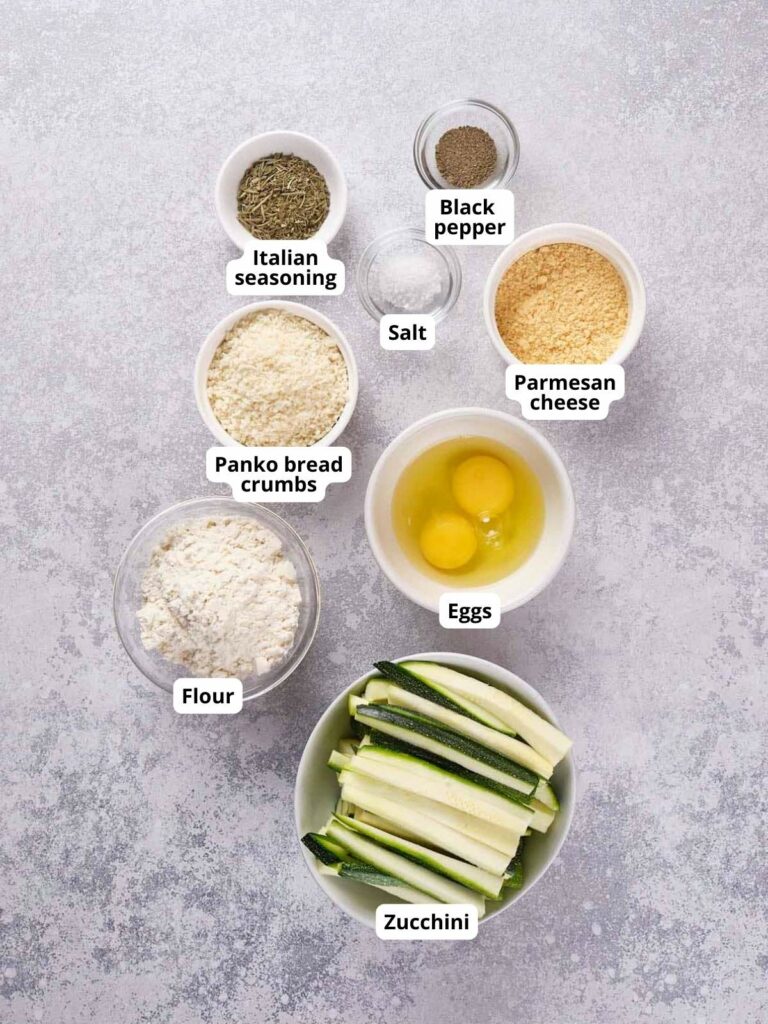 A top view of various ingredients in bowls arranged on a gray countertop.