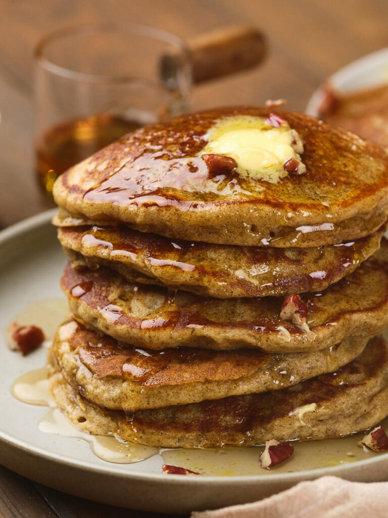 A stack of pumpkin pancakes made with pancake mix, topped with butter.