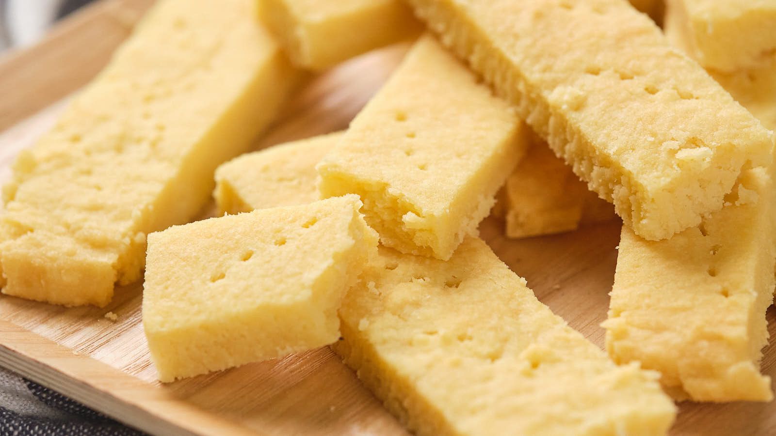 A close-up of several rectangular pieces of shortbread placed on a wooden surface.