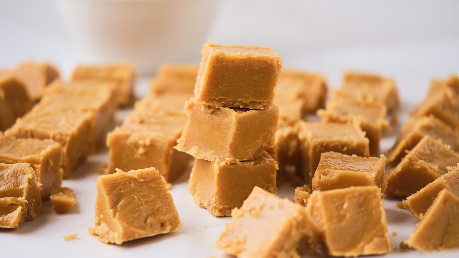 Close-up of multiple pieces of peanut butter fudge, with several pieces stacked on top of each other in the center.