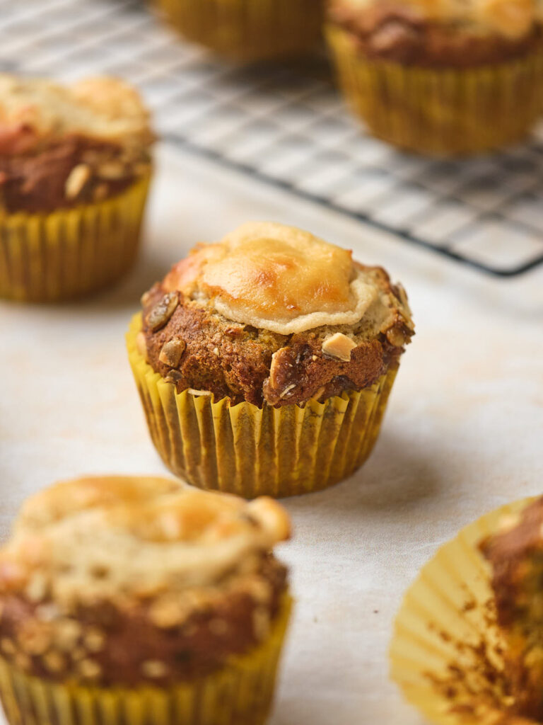 Close-up of a batch of pumpkin and cream cheese muffins in yellow paper liners.