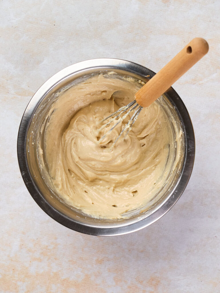 A stainless steel bowl containing a thick, pale batter mixture.