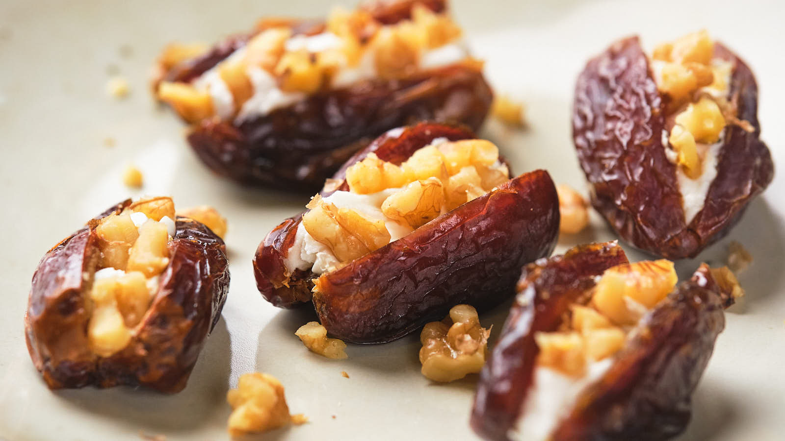 Stuffed dates with cream cheese and walnuts on a plate.