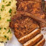 A serving of seasoned pork chops on a white plate.