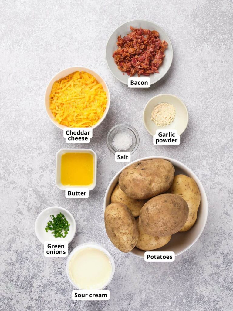 Ingredients for potato skin recipe are arranged on a light colored surface, each labeled.