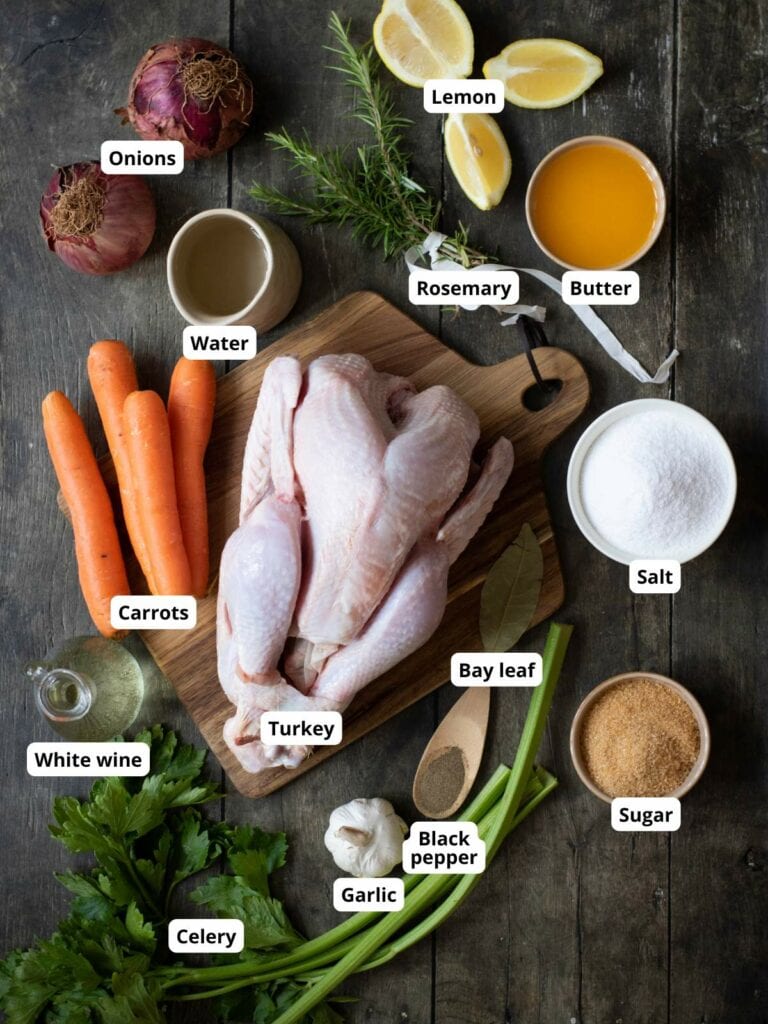 Ingredients for roasted turkey are arranged on a wooden table.