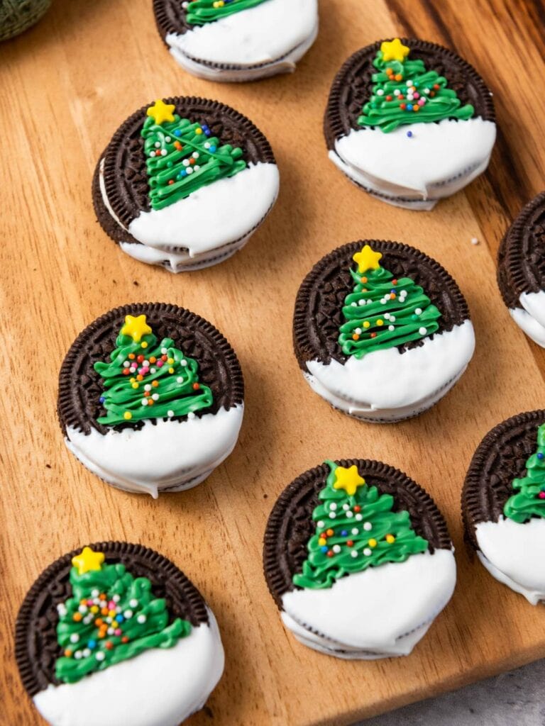 Christmas tree oreos arranged on a wooden surface.