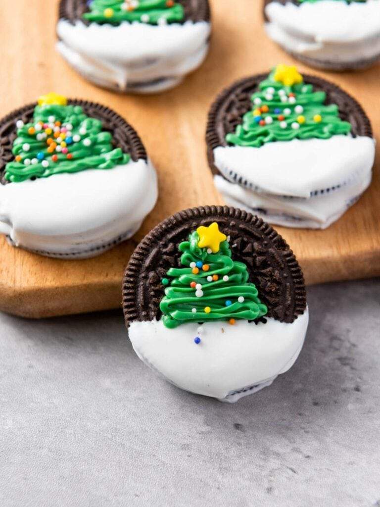 Christmas tree oreos arranged on a wooden board.