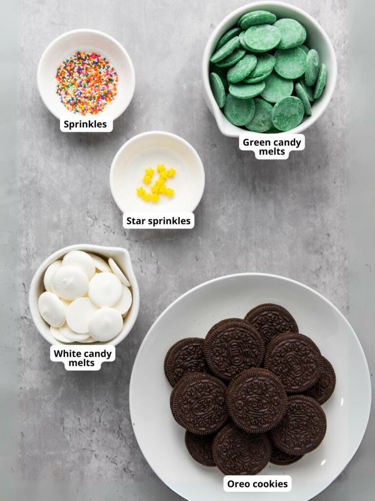 Ingredients for a recipe: bowls of sprinkles, candy melts, star sprinkles, and Oreo cookies.