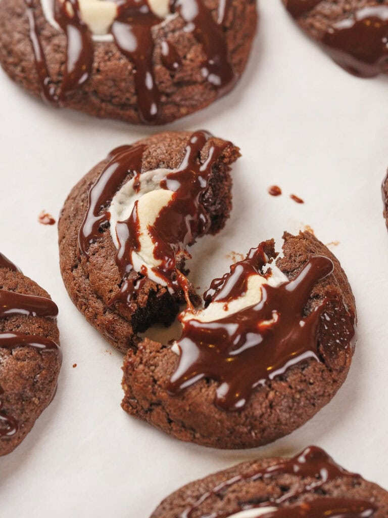 Chocolate cookies topped with marshmallows, drizzled with melted chocolate.