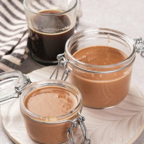 Two sealed jars of peppermint mocha coffee creamer on a plate.