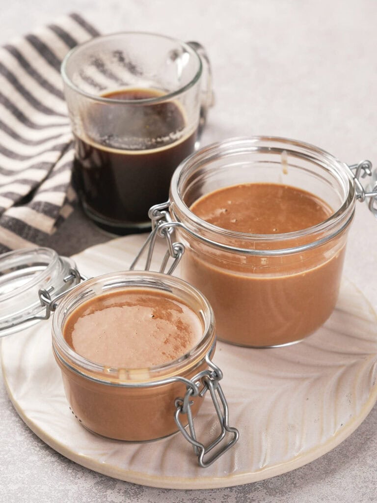 Two sealed jars of peppermint mocha coffee creamer on a plate.