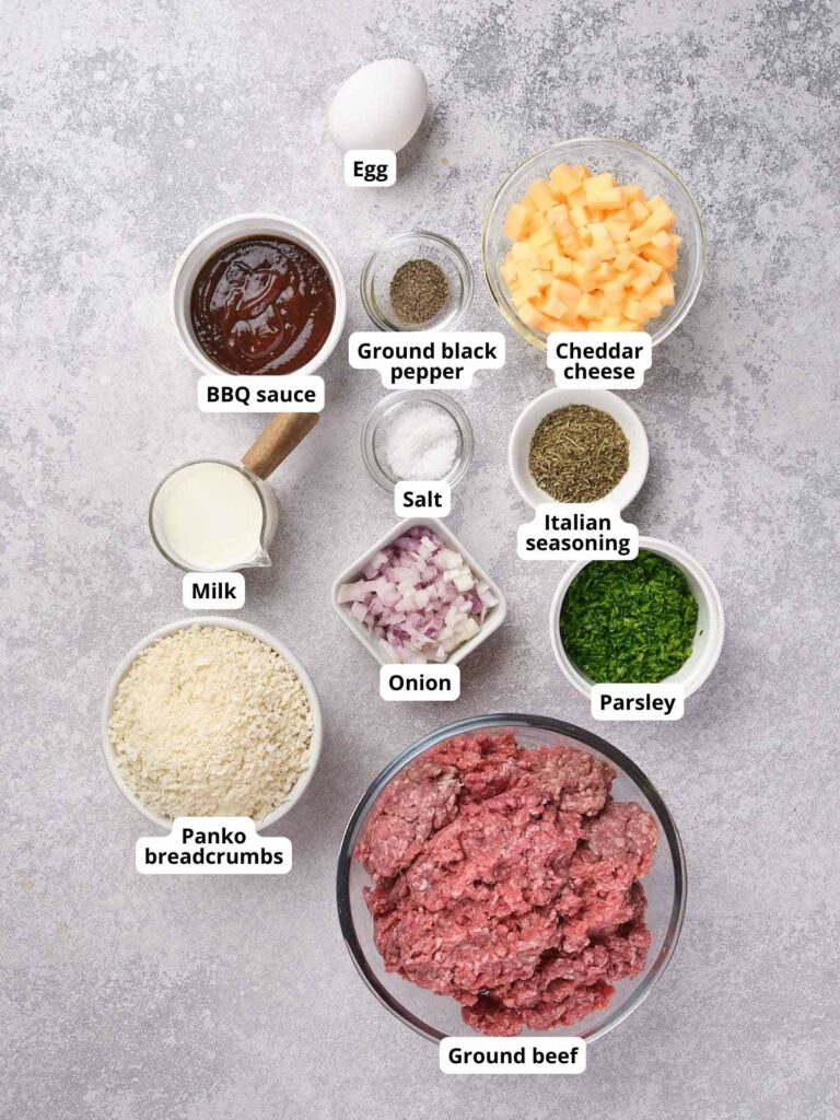 Ingredients for stuffed meatloaf are arranged on a light colored surface.