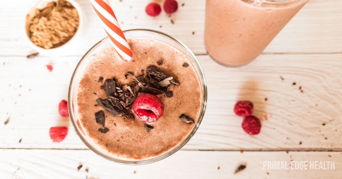 Chocolate Raspberry Smoothie in glass with red and white straw.