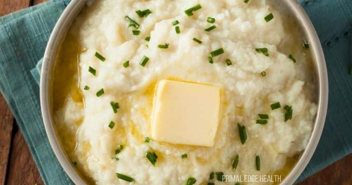 Mashed cauliflower potatoes with butter on top in a bowl.