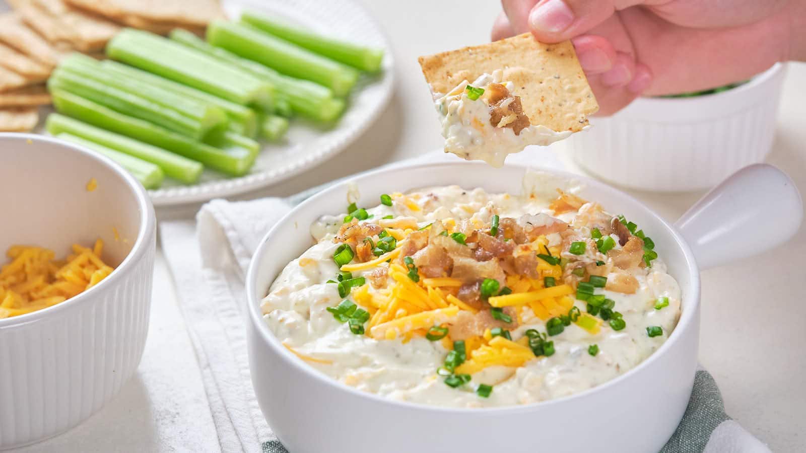 Bacon cheddar dip with shredded cheddar cheese, bacon bits, and chive garnish.