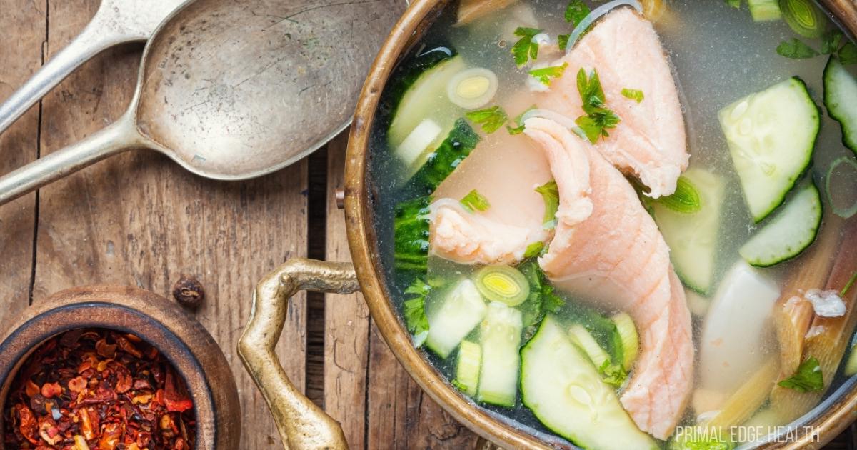 Fish stock in bowl with ingredients around.