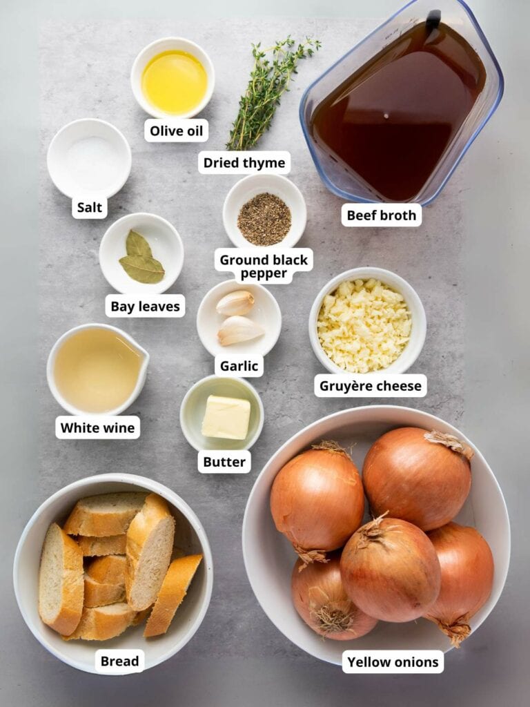 Ingredients for French onion soup on a surface, each labeled.