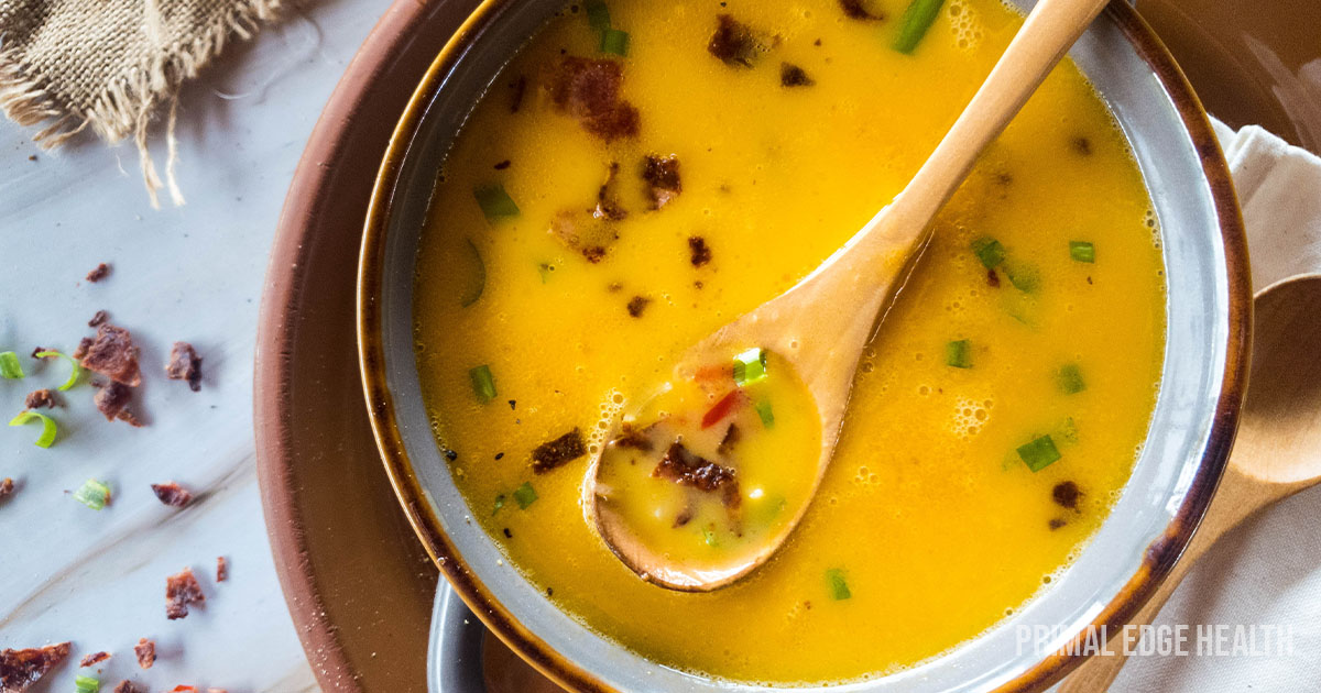 Beer cheese soup with wooden spoon in a bowl.