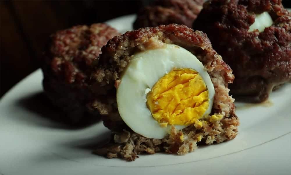 Scotch eggs with ground beef one cut in half.