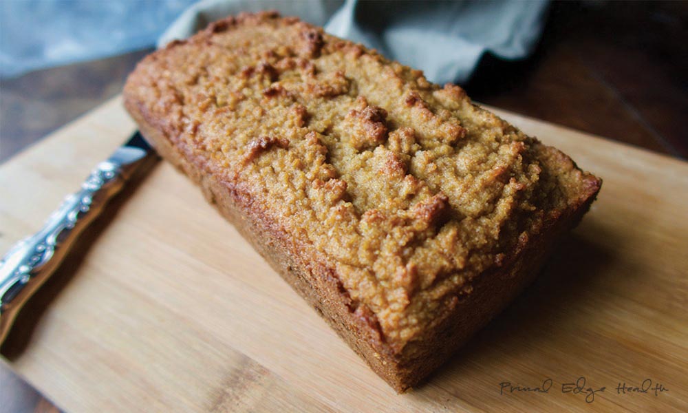 Gingerbread on wooden cutting board with knife.