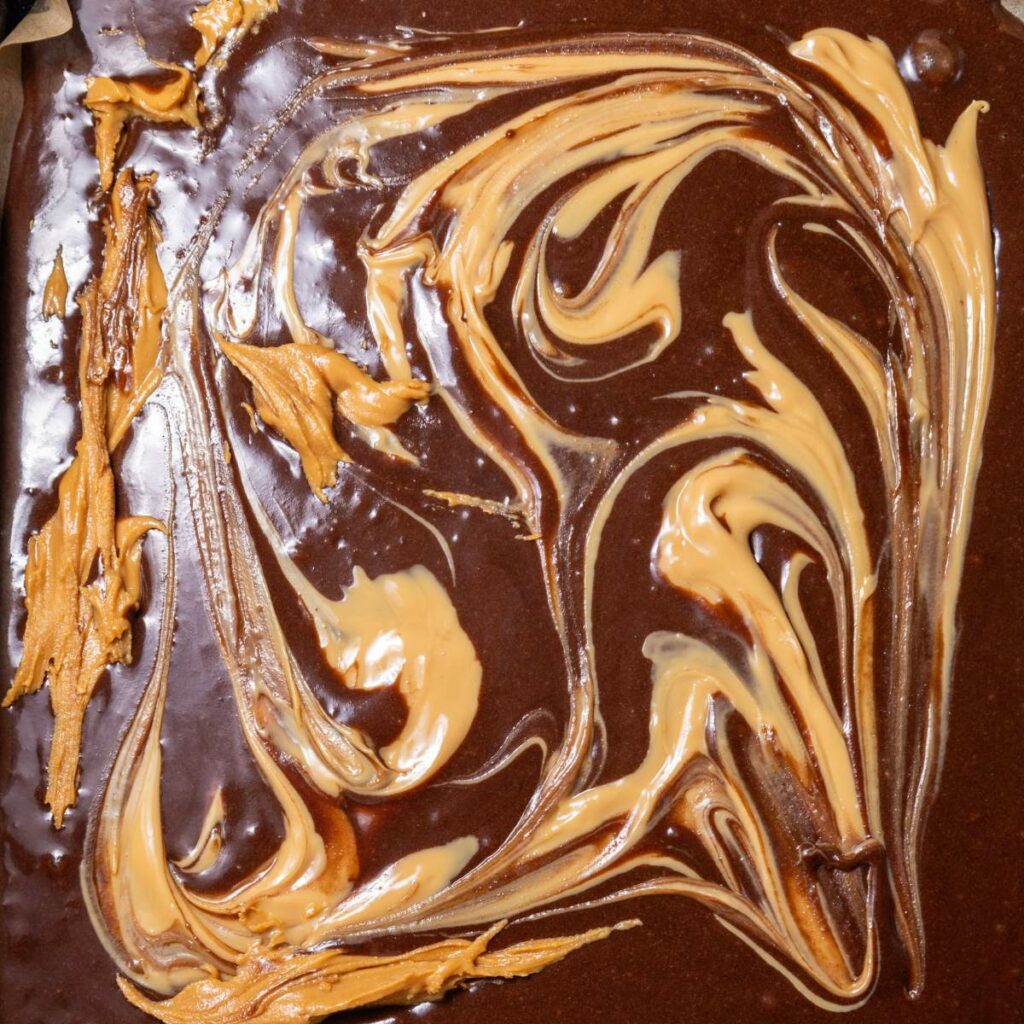 Swirled mixture of chocolate and peanut butter spread on a surface.